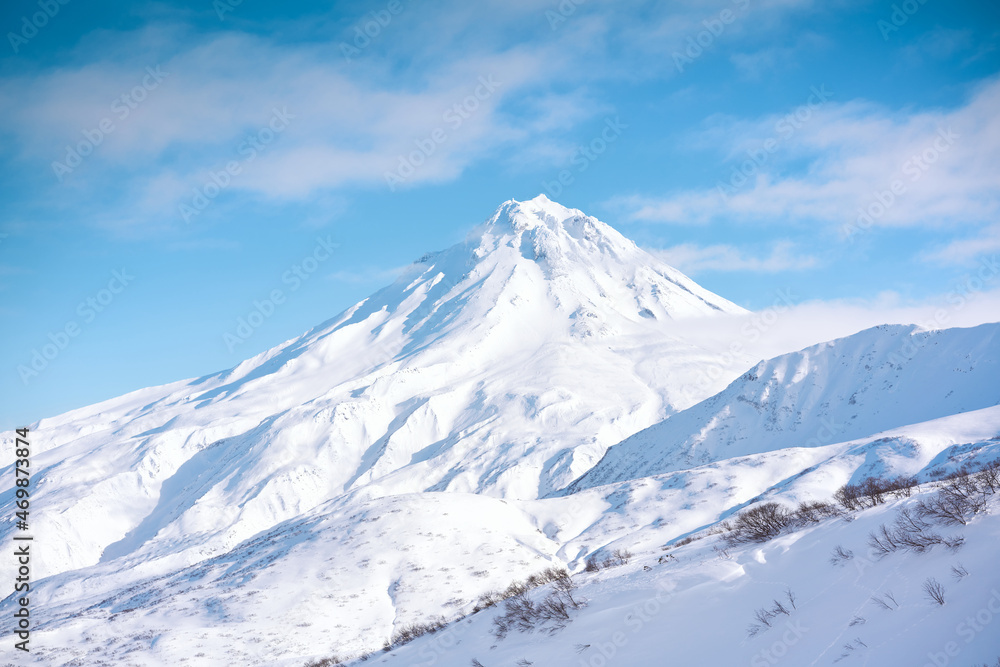 Winter landscape. Vilyuchinsky volcano covered with snow against blue sky. Kamchatka peninsula, Russia Winter landscape. Vilyuchinsky volcano covered with snow against blue sky. Kamchatka peninsula, Russia