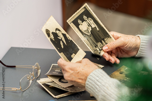 An old woman looking through family album. Generations and values concept.