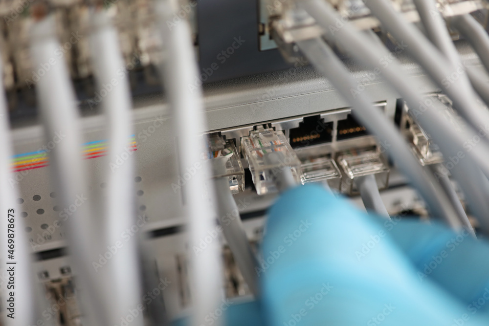 Technician hand connect switch ethernet cables and port to internet switch Technician hand connect switch ethernet cables and port to internet switch