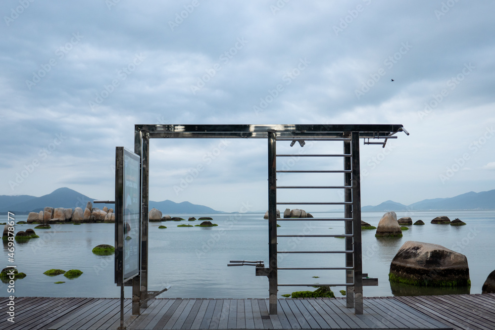 pier on the beach, outdoor gym overlooking the calm sea with mountains in the background pier on the beach, outdoor gym overlooking the calm sea with mountains in the background