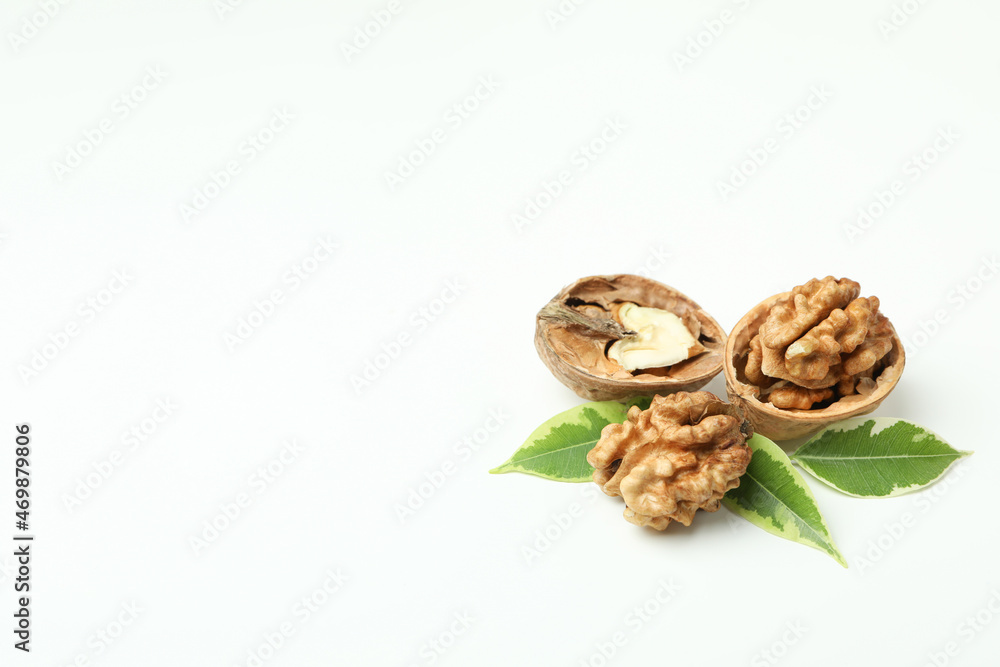 Walnuts with nutshell and leaves on white background Walnuts with nutshell and leaves on white background
