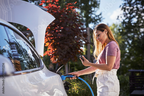 Woman charging electric car photo