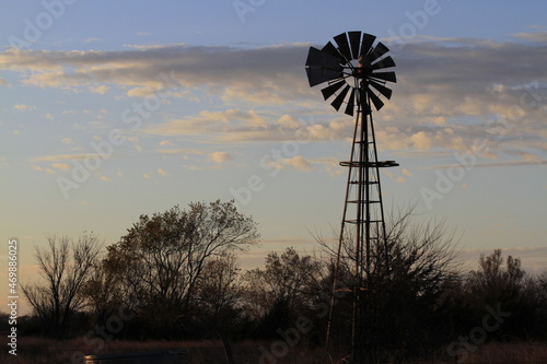 windmill at sunset with a colorful sky north of Hutchinson Kansas USA with clouds.