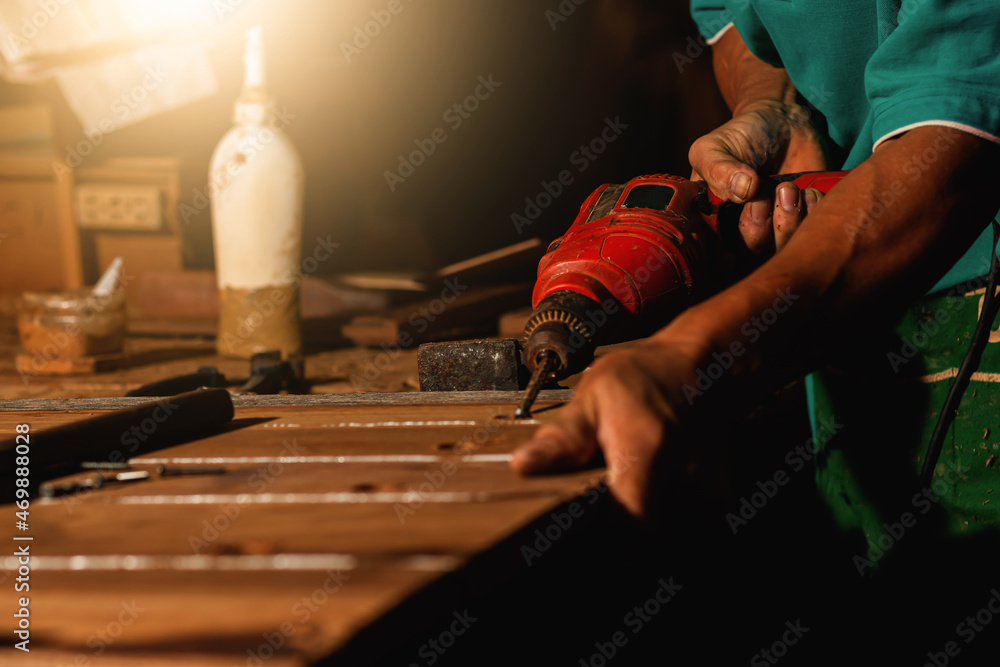 Close-up of a carpenter using a circular saw or a tool to cut wooden planks To make furniture in homes and residences, hotels, rooms made of wood. Close-up of a carpenter using a circular saw or a tool to cut wooden planks To make furniture in homes and residences, hotels, rooms made of wood.