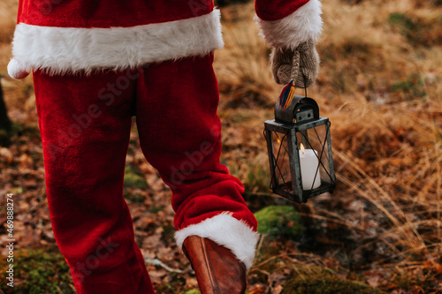 Person wearing Santa costume holding lantern photo