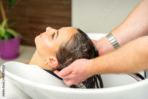 Beautiful caucasian woman washing hair in a beauty salon