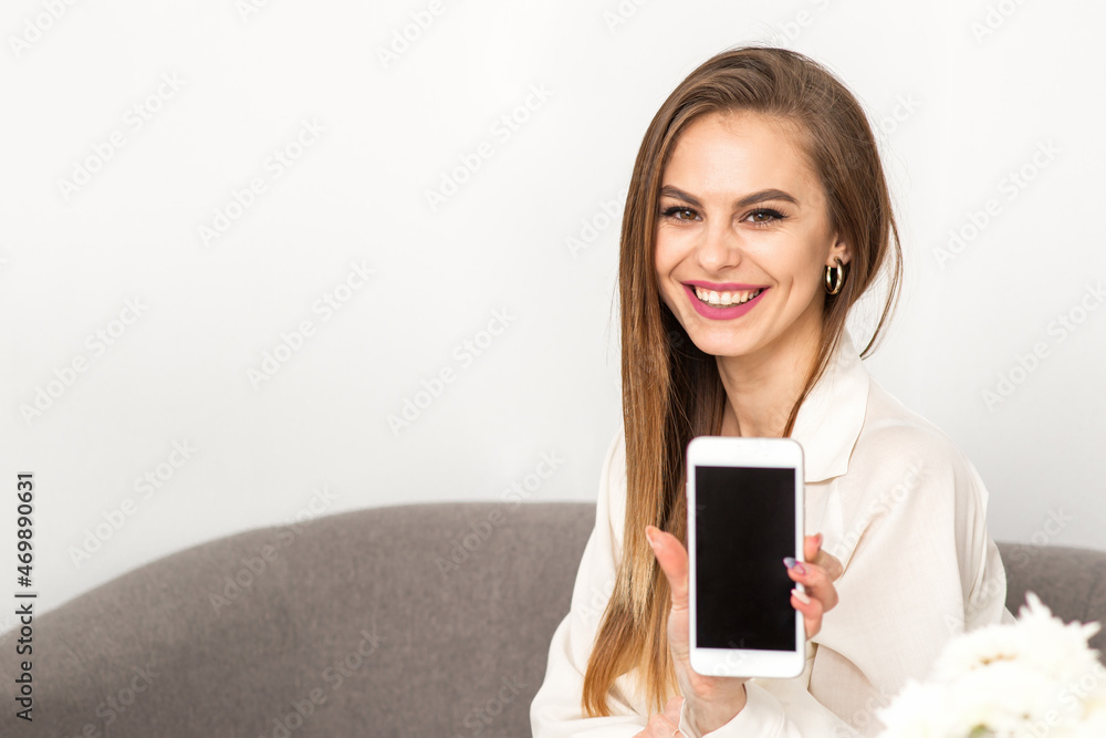 Two smiling female doctors wearing white medical gowns with empty smartphone screen in a medical office, mockup, copy space Two smiling female doctors wearing white medical gowns with empty smartphone screen in a medical office, mockup, copy space