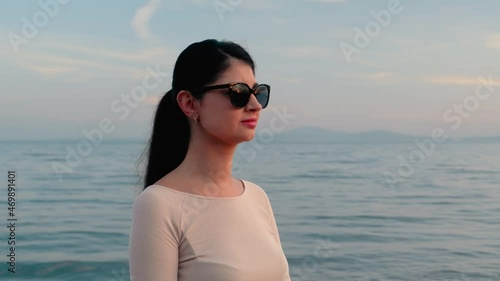 beautiful woman at the sea in sunglasses with reflection on the landscape