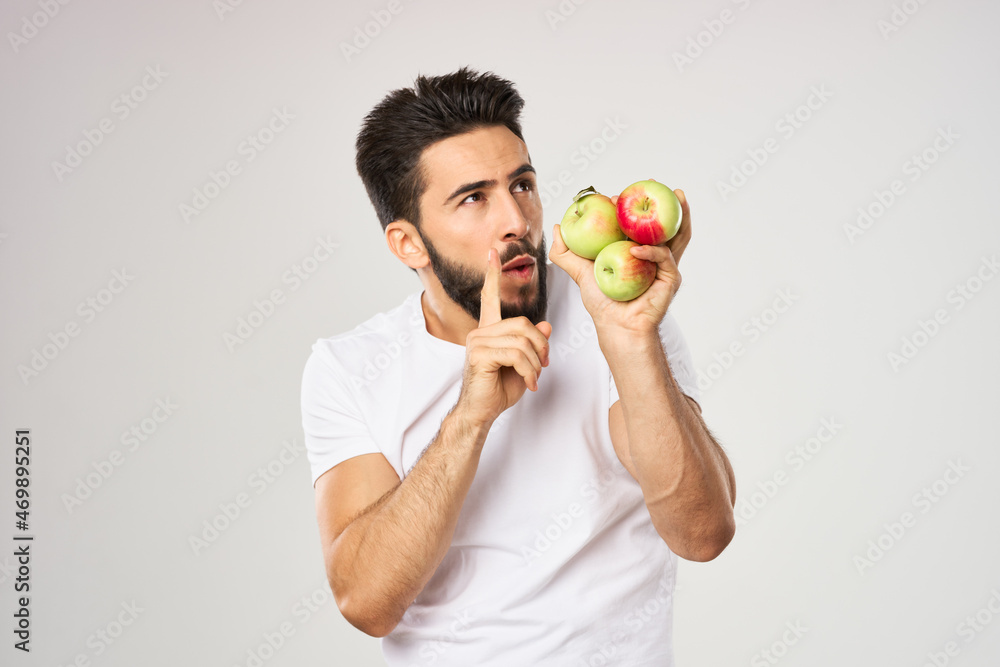 Cheerful man with apples in his hands in a white t-shirt fruits Cheerful man with apples in his hands in a white t-shirt fruits