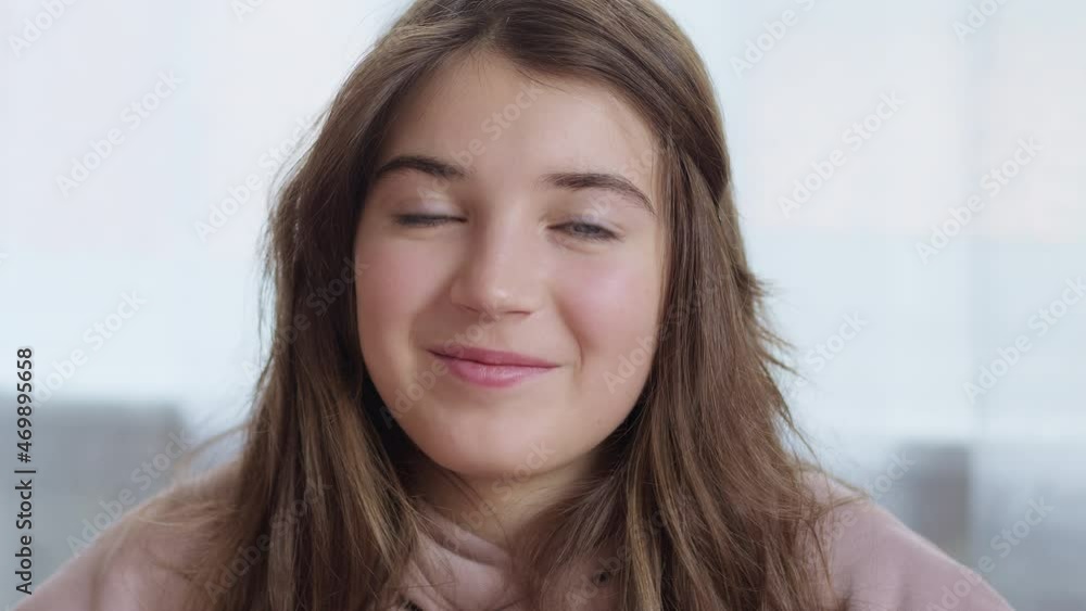 Portrait of a smiling beautiful teenage girl looking at the camera. The face of a happy schoolgirl. Close-up in the interior. Portrait of a smiling beautiful teenage girl looking at the camera. The face of a happy schoolgirl. Close-up in the interior.