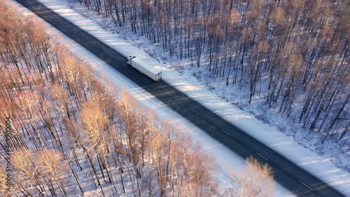 A white truck with a long trailer carries refrigeration equipment for grocery stores. Transportation of products in winter. Top view. High quality. 4k footage.