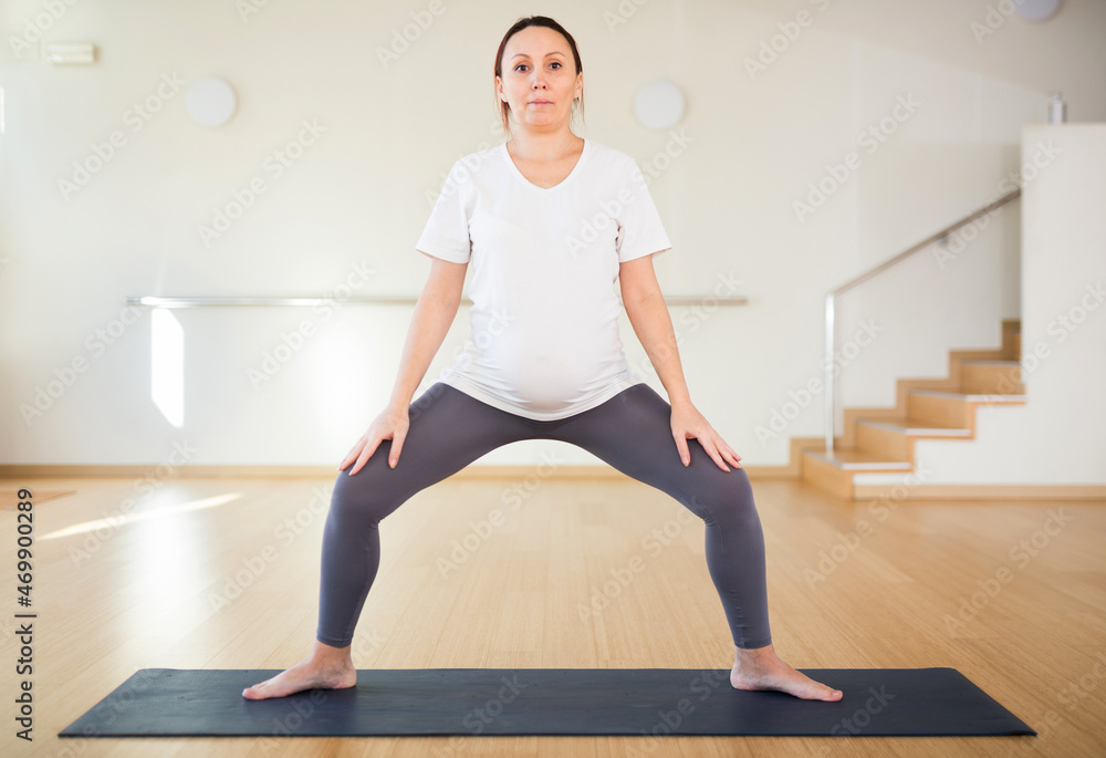 Pregnant woman practices yoga. Goddess Pose or utkata konasana