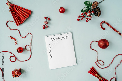 Red Christmas baubles decoration around blank notebook.