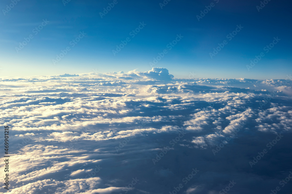 Naklejka premium A mass of cumulus, wavy clouds in the Earth's atmosphere. A view from above. A view of the clouds from an aircraft window.