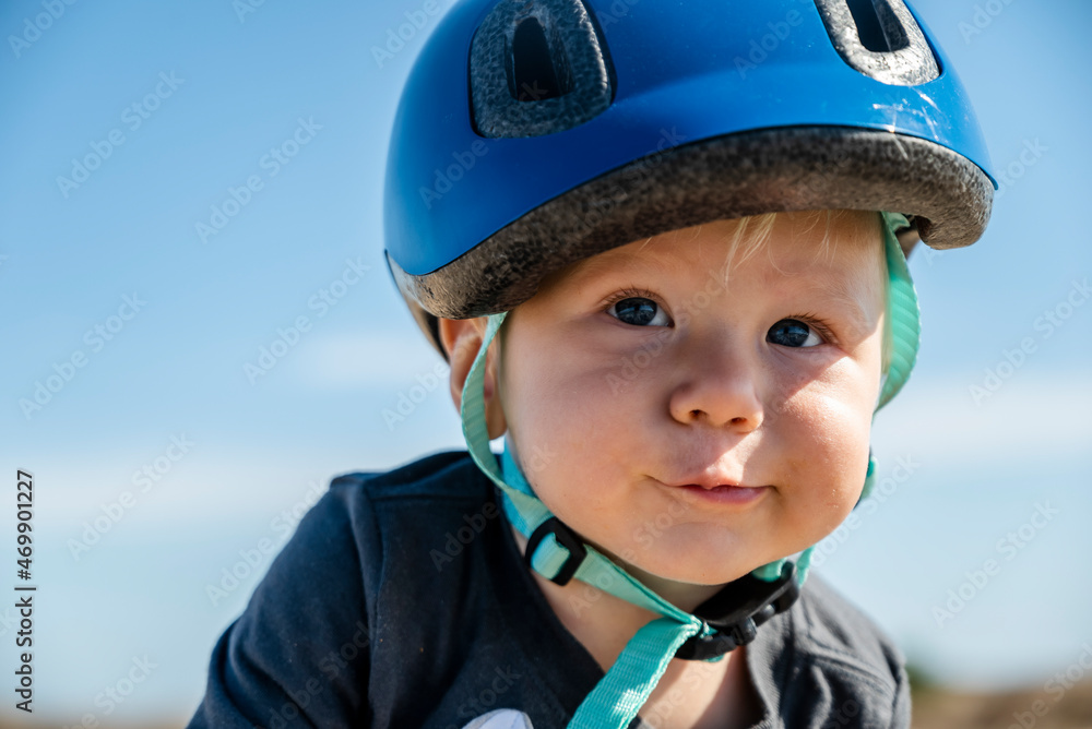 Portrait of a cute baby boy wearing blue bicycle helmet against blue sky Portrait of a cute baby boy wearing blue bicycle helmet against blue sky