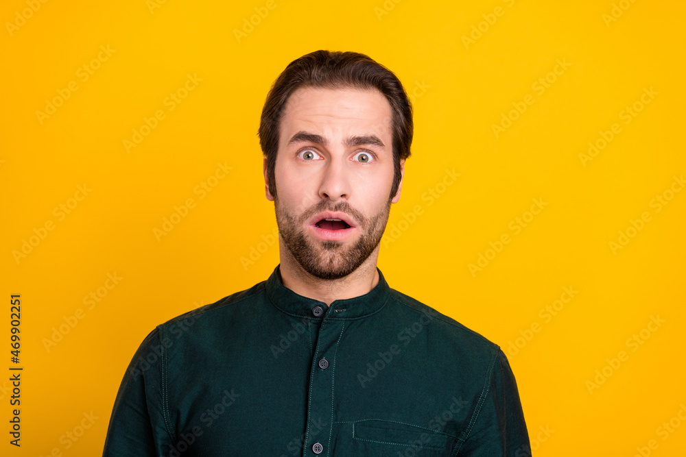 Photo of fear millennial guy open mouth wear green shirt isolated on yellow color background Photo of fear millennial guy open mouth wear green shirt isolated on yellow color background