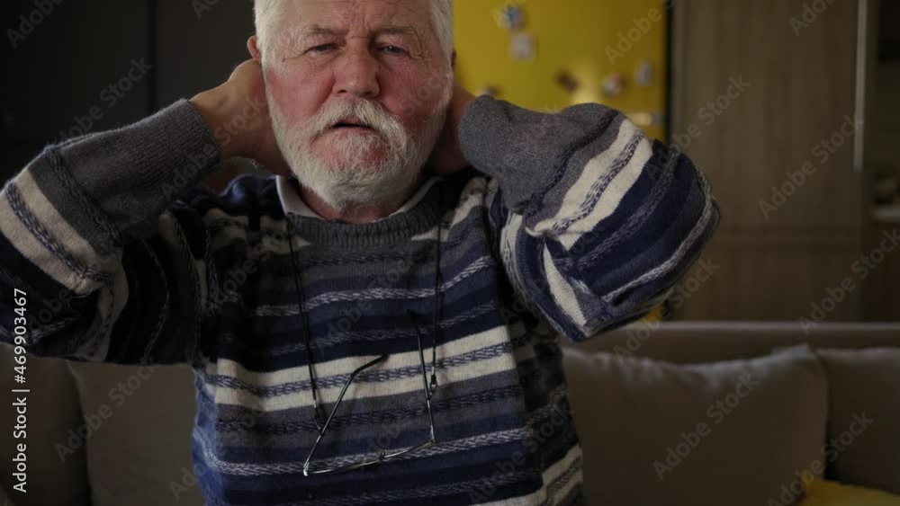 Retired elderly man suffering for neck pain at home Retired elderly man suffering for neck pain at home