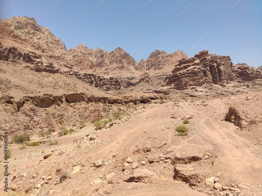 Dana, la plus grande réserve naturelle de Jordanie, marche en plein milieu d'une zone montagneuse rouge et blanche, avec un peu de verdure et de la forte chaleur, sans ombre, parcourir desert et herbe