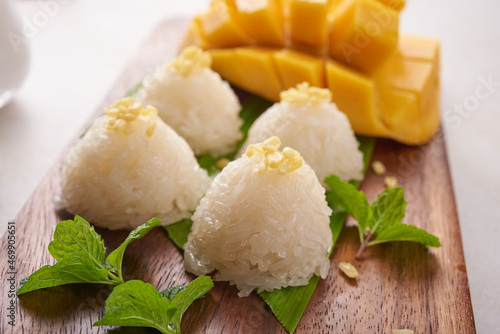 Ripe mango and sticky rice with coconut milk on wood plate on stone background, Tropical fruit. Dessert fruit. Thai sweet dessert on summer season.