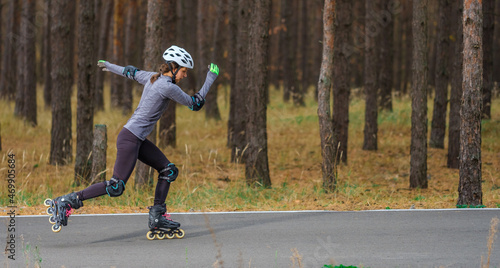 Roller skating sports girl in a helmet outdoors.