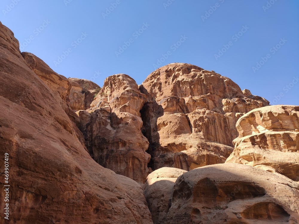 La petite cité nabatéenne Petra, en Jordanie, ancien chemin et historique de transport ou vente de produits locaux, des habitations taillées dans la roche, failles et ombre, être à l'ombre et grimper