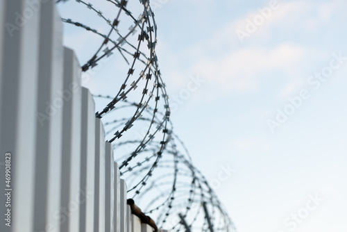 Close-up of a barbed wire fence against a clear blue sky. The concept of striving for freedom.