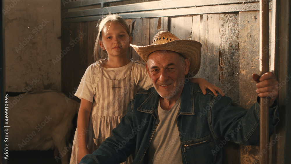 Grandfather and granddaughter in barn