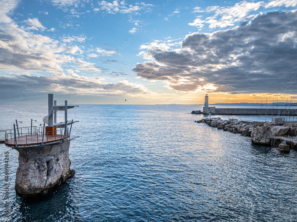 Coucher de soleil sur la mer vers le plongeoir et le phare du port Lympia de Nice sur la Côte d'Azur