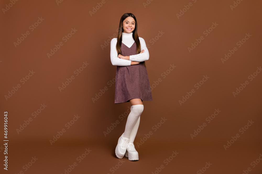 Full size photo of young pretty girl wear modern outfit uniform smart pupil isolated over brown color background Full size photo of young pretty girl wear modern outfit uniform smart pupil isolated over brown color background