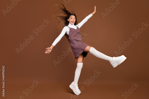 Full body profile side photo of young excited girl have fun wear platform casual outift isolated over brown color background © deagreez