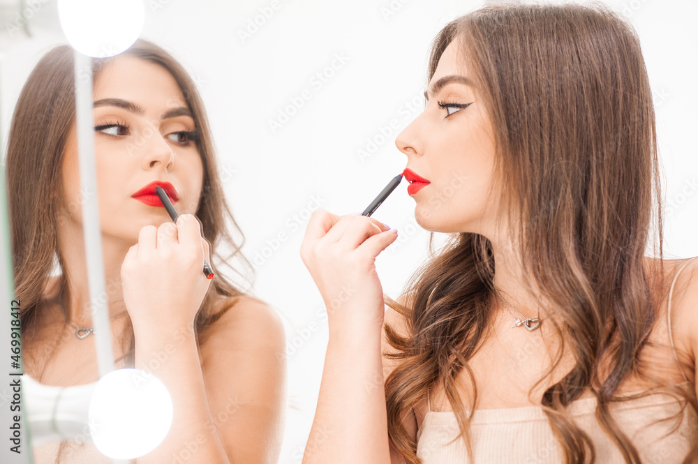 Makeup artist applies lips pencil . Beautiful woman face. Hand of visagiste, painting cosmetics of young beauty model girl . Make up in process Makeup artist applies lips pencil . Beautiful woman face. Hand of visagiste, painting cosmetics of young beauty model girl . Make up in process