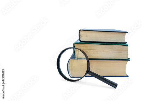 A stack of books with a magnifying glass on white background  empty space for your message