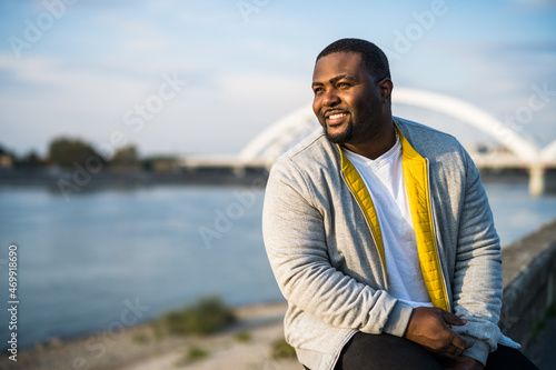 Happy black man enjoys resting by the river.