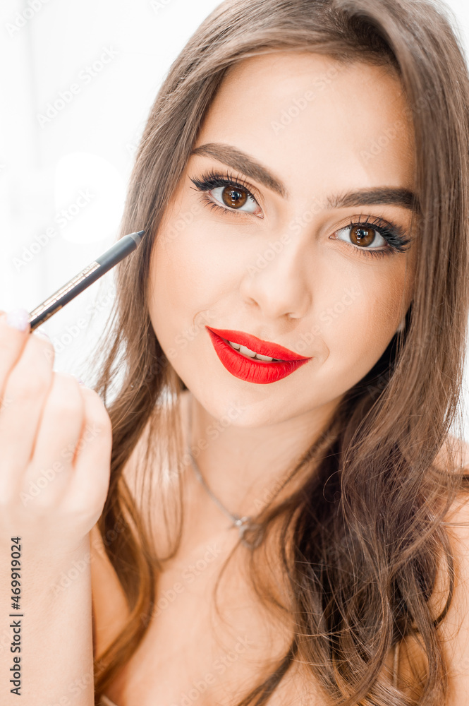 Young beautiful woman applying make up
