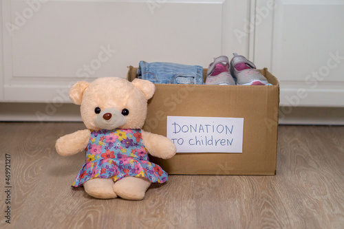 The donation box for clothes for children is not on the floor. Toys and baby stuff in the box. Donation and charity concept