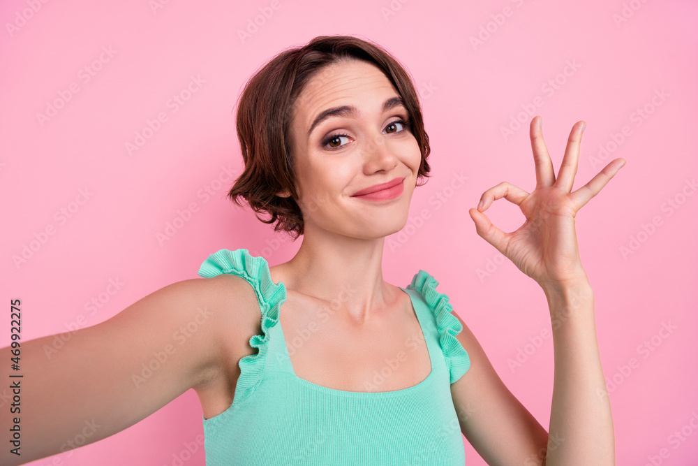 Photo of cute sweet young woman dressed turquoise tank-top recording video showing okey isolated pink color background Photo of cute sweet young woman dressed turquoise tank-top recording video showing okey isolated pink color background