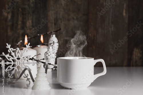 Christmas decor, burning candles, steaming coffee cupagainst dark wood background. Xmas, winter, new year concept, copy space