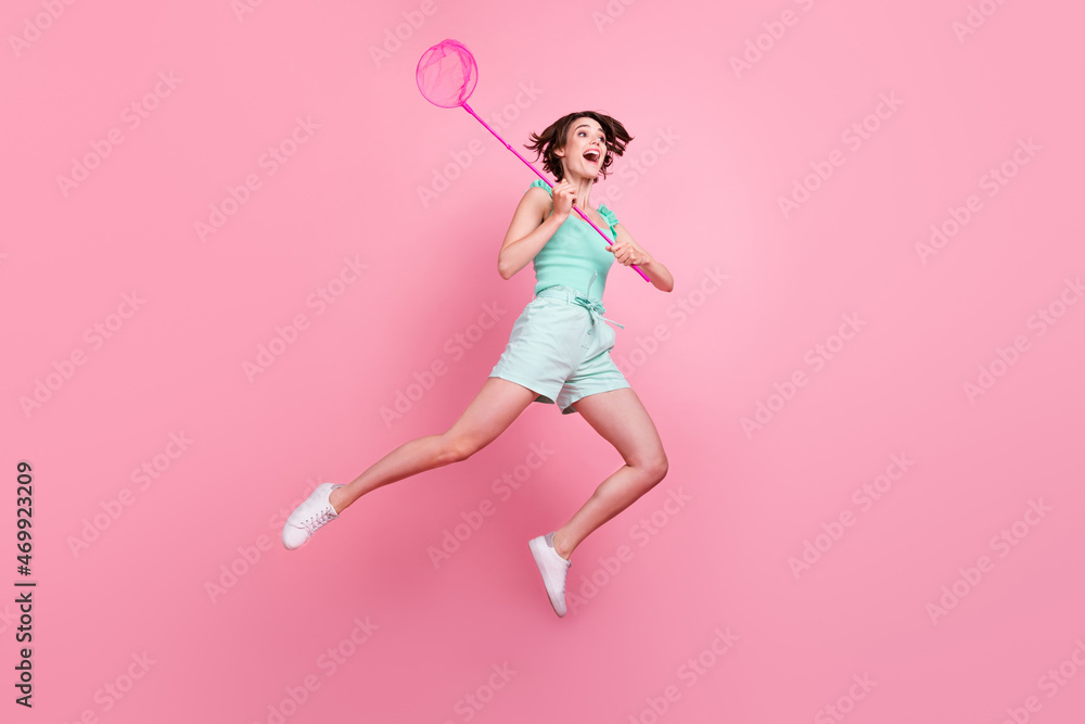 Full length body size view of attractive amazed cheerful girl jumping holding using net isolated over pink pastel color background Full length body size view of attractive amazed cheerful girl jumping holding using net isolated over pink pastel color background