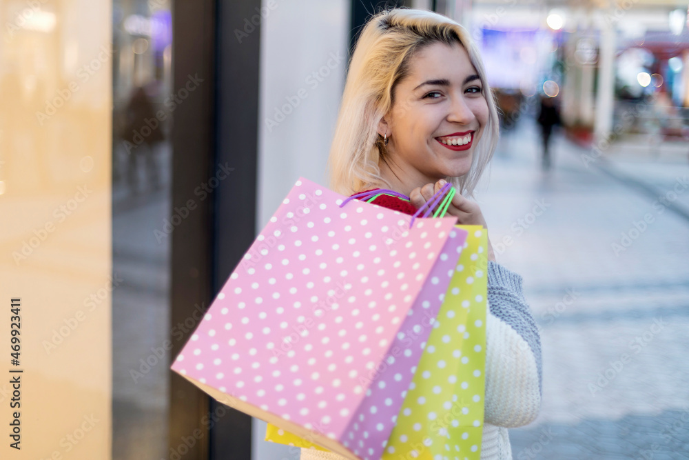 beautiful young blonde woman smiling with shopping bags outside beautiful young blonde woman smiling with shopping bags outside
