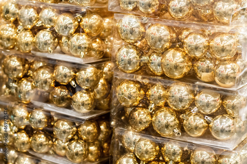 Golden christmas ornaments balls baubles in plastic boxes. Christmas shopping concept. Holidays retail sale