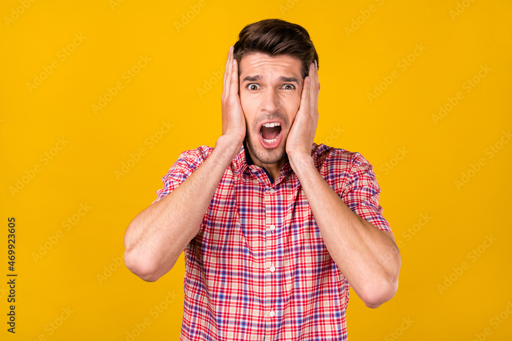 Portrait of attractive amazed worried overwhelmed guy sudden news reaction isolated over bright yellow color background Portrait of attractive amazed worried overwhelmed guy sudden news reaction isolated over bright yellow color background