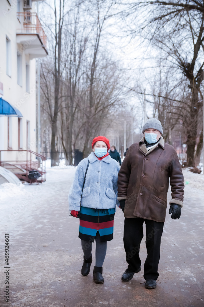 Elderly woman and man in protective medical masks on   street.
