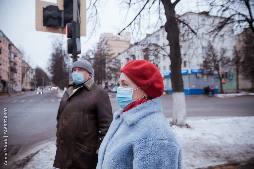 Senior couple on street in winter in medical masks during coronavirus Senior couple on street in winter in medical masks during coronavirus