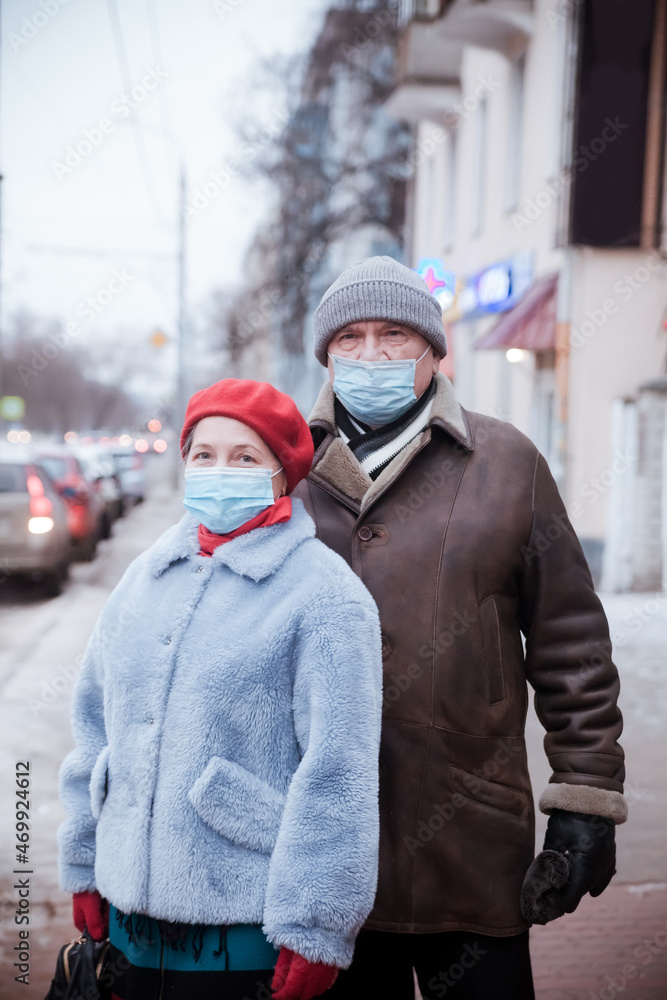 Couple of pensioners on   street in winter during   coronavirus
