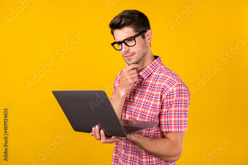 Tableau sur toile Portrait of attractive trendy focused guy geek hacker using laptop reading repor