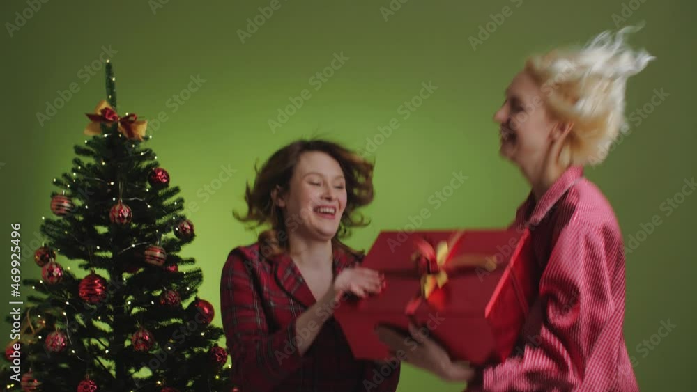 Two Girls wearing pajamas fighting for a gift red box. Christmas decoration. Two Girls wearing pajamas fighting for a gift red box. Christmas decoration.
