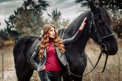 Beautiful young woman posing with a horse outdoors, close up