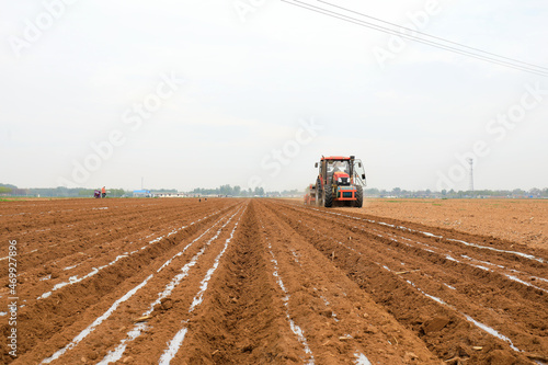 Farmers use planters to plant plastic coated peanuts on farms  North China