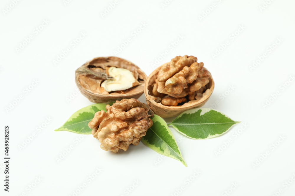 Walnuts with nutshell and leaves on white background Walnuts with nutshell and leaves on white background