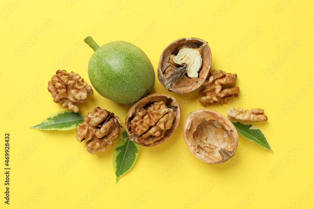 Walnuts with nut peel on yellow background Walnuts with nut peel on yellow background